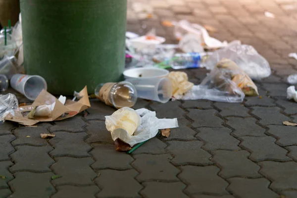 Dışarıdan taşan çöplerle dolu plastik çöp resmi.