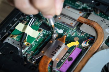 Bilgisayarın devrelerini tamir eden bir elektrikçinin yakın plan fotoğrafı.