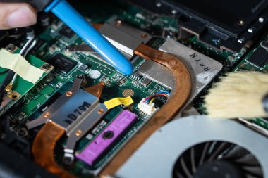 Bilgisayar anakartını temizleyen bir elektrikçi resmi