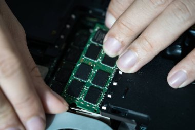 Bilgisayarın devrelerini tamir eden bir elektrikçinin yakın plan fotoğrafı.