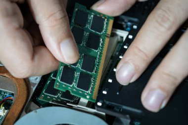 Bilgisayarın devrelerini tamir eden bir elektrikçinin yakın plan fotoğrafı.