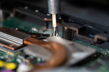 Bilgisayarın devrelerini tamir eden bir elektrikçinin yakın plan fotoğrafı.