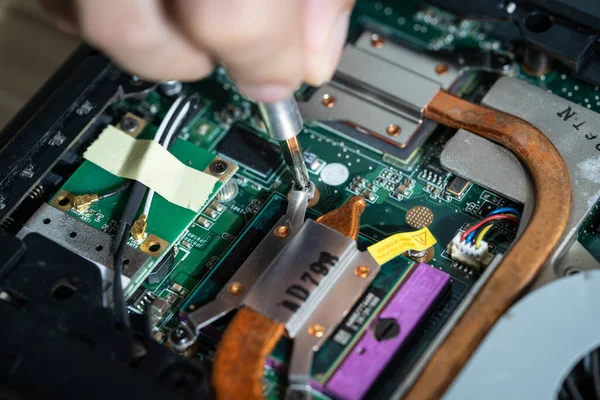 Close-up photo of an electrician repairing the computer's circuit