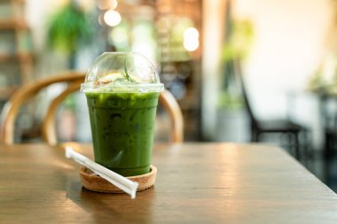 Masanın üzerinde şeffaf plastik bardaklarla yeşil çay içerken çekilmiş bir resim.