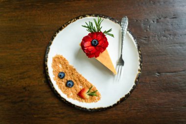 Beyaz fayanslı tabaklar üzerinde güzel dekore edilmiş pastaların ve eski ahşap masaların arka planının en üst görüntüsü.