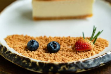 Beyaz fayanslı tabaklar üzerinde güzel dekore edilmiş pastaların ve eski ahşap masaların arka planının en üst görüntüsü.