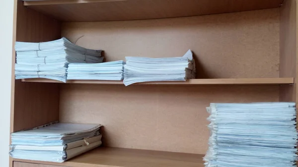 Stacks of documents lying in an office cabinet.