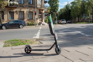 Bir elektrikli scooter şehir merkezinde bir kavşakta park edilmiş.