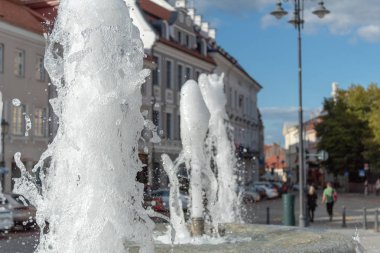 Belediye meydanında ferahlatıcı çeşme. Sıcak yaz günü. Vilnius, Litvanya.