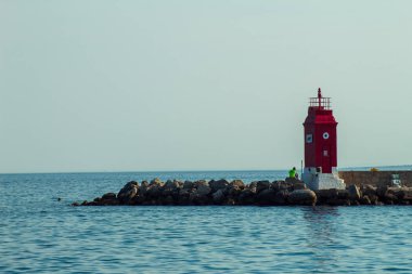 Deniz manzarası: turkuaz su, akşam gökyüzü, deniz feneri yakın çekim. Krk, Krk adası, Hırvatistan.