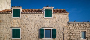 Yeşil pencereler ve mavi gökyüzü, meditasyon kavramı, yaz günü ile Taş ev 