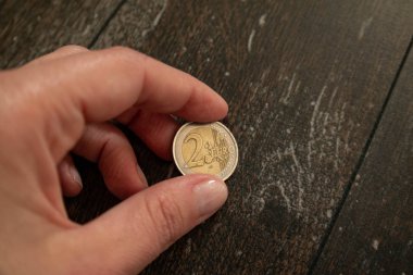 Beyaz el karanlık zemin, koyu arka plan, kopya alanı, finans ve bankacılık kavramı üzerinde 2 € tutarak