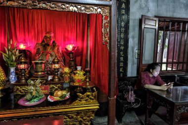 Hanoi, Vietnam - 30 Ağustos: 30 Ağustos 2018'de Hanoi, Vietnam'daki Quan Thanh Tapınağı'nda cep telefonuna bakan bir kadın.