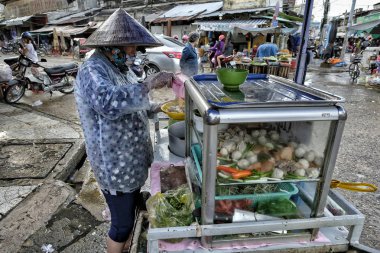 My Tho, Vietnam - 9 Ağustos: Bir kadın 9 Ağustos 2018 tarihinde My Tho, Vietnam'da sokak pazarında meyve ve sebze satıyor.