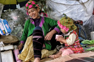 Sapa, Vietnam - August 24: Hmong woman with her daughter at the market on August 24, 2018 in Sapa, Vietnam. Sapa is famous for its rugged scenery and its rich cultural diversity. clipart