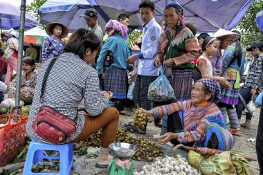 Bac Ha, Vietnam - 26 Ağustos: Geleneksel elbiseli hmong kadınlar 26 Ağustos 2018 tarihinde Bac Ha, Vietnam'da pazarda sebze satan.