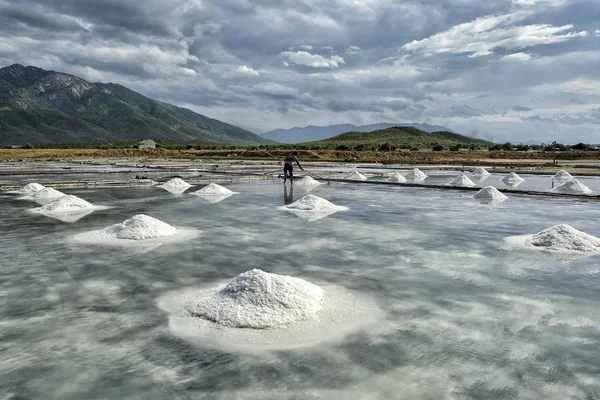 Men organize salt into piles at the Hon Khoi salt fields in Nha Trang, Vietnam.