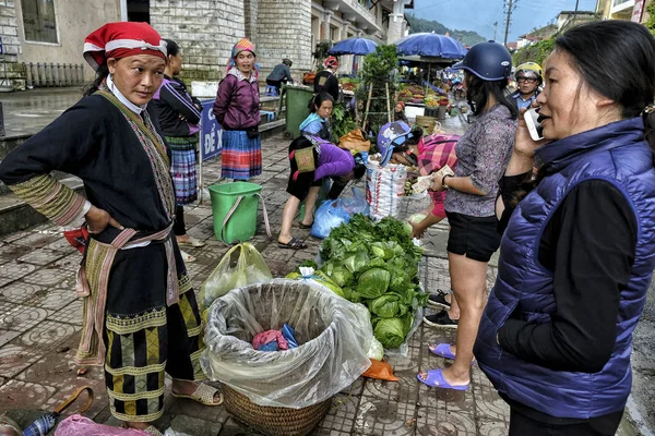 Sapa, Vietnam - 24 Ağustos: 24 Ağustos 2018'de Sapa, Vietnam'da pazarda puslu bir günde dong yaprağı satan Kırmızı Dao kadınları. Sapa engebeli manzarası ve zengin kültürel çeşitliliği ile ünlüdür..
