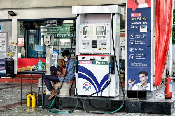 インド 2020年5月 2020年5月31日にインド ケーララ州高知でマスクをしながら携帯電話を見るガソリンスタンド労働者 ストックフォト