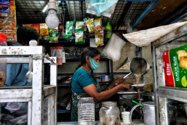Kochi, India - May 2020: A woman making tea at a street stall on May 29, 2020 in Kochi, Kerala, India. clipart