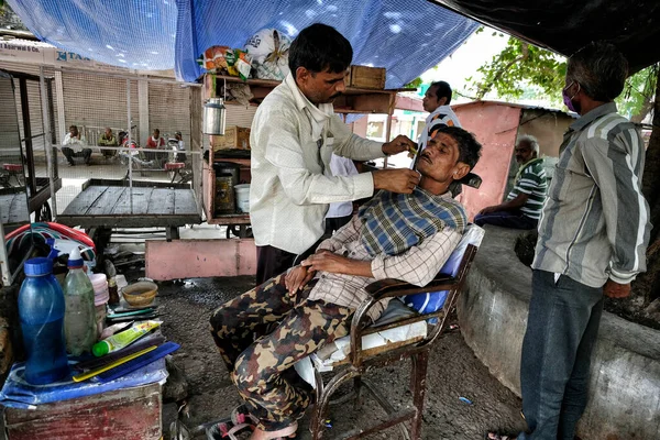 Bundi, Hindistan - Ağustos 2020: Rajasthan 'ın Bundi kentindeki eski Bundi kasabasında bir ağacın altında çalışan bir berber. Hindistan