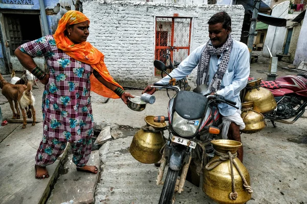 Bundi, Hindistan - Ağustos 2020: 10 Ağustos 2020 'de Rajasthan' ın Bundi kentinde, eski Bundi kasabasında bir sokak satıcısından süt alan bir kadın. Hindistan