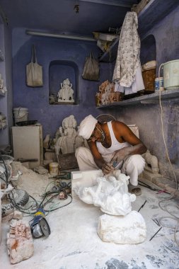 Jaipur, Hindistan - Ağustos 2020: 27 Ağustos 2020 tarihinde Hindistan 'ın Rajasthan kentinde Jaipur şehrinde mermer bir heykel üzerinde çalışan bir zanaatkar.