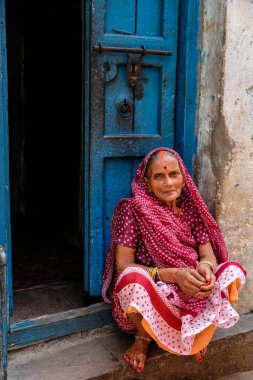 Varanasi, Hindistan - Eylül 2020: 11 Eylül 2020 'de Hindistan' ın Uttar Pradesh kentindeki evinin kapısında oturan bir kadın.
