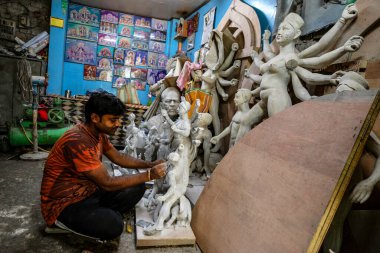 Kolkata, Hindistan - Eylül 2020: Kuzey Kolkata 'nın çömlekçi bölgesi Kumartuli' deki Durga Puja festivali için 28 Eylül 2020 'de Batı Bengala, Hindistan' da kil ve saman heykelleri yapan bir zanaatkar.