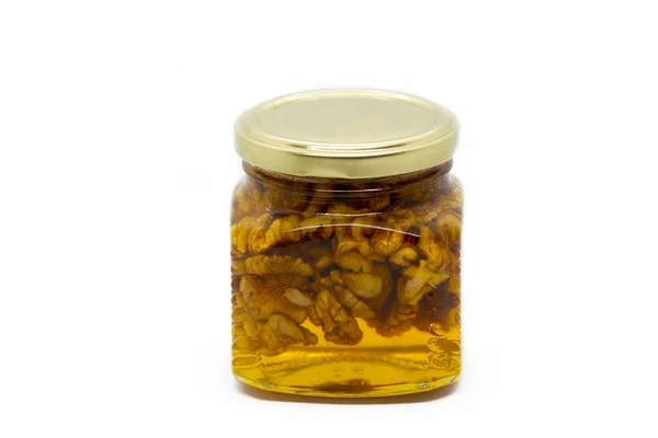 白い背景に蜂蜜とクルミのガラス瓶 — ストック写真