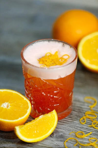 Bacardi cocktail with orange and orange zest on a gray background