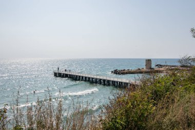 Poseidon heykeli, mavi deniz ve gökyüzü, tatil beldesi ile bir iskelede insanlar - St Constantine ve Elena, Varna, Bulgaristan