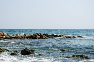 Güzel vahşi sahil manzarası, güneşli bir gün, kayalıklara vuran su dalgaları, yaz manzarası.