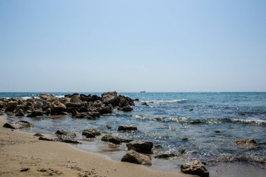 Güzel vahşi sahil manzarası, güneşli bir gün, kayalıklara vuran su dalgaları, yaz manzarası.