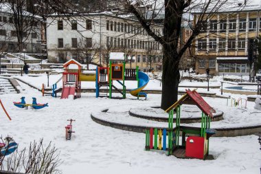 Bulgaristan 'ın Smolyan kentinde kış mevsimi, boş çocuk parkı, karla kaplı oyuncaklar, karla kaplı oyun alanı, spor birimleri