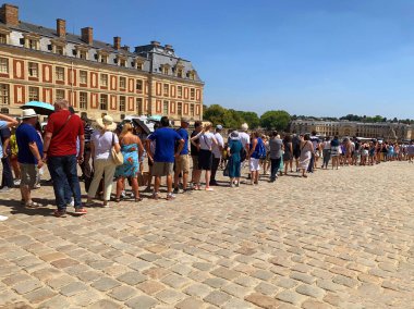Versailles / Fransa - 6 Temmuz 2019: Paris, Fransa, yaz saatinde biletlerini bekleyen Versailles Sarayı'nda son derece büyük turist kuyruğu. Kral Louis 14, ünlü turistik 