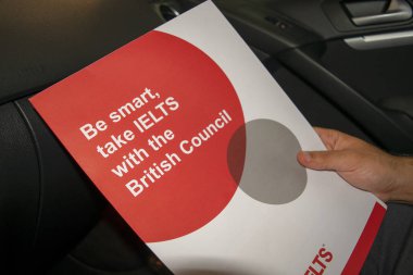 Dubai / Birleşik Arap Emirlikleri - 14 Ağustos 2019: Ielts sonuçları British Council'dan arabada erkek elleriyle sarıyor 