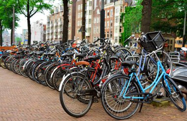 Amsterdam / Hollanda - 11 Temmuz 2019: Bisiklet dolu bisiklet park istasyonu. Amsterdam caddesinde park etmiş birçok farklı bisiklet. Bisiklet park etme. 