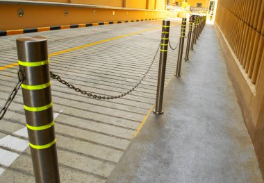 Yaya geçidi boyunca zincirli metal çit. Balustrade yol kenarından ayrılar.
