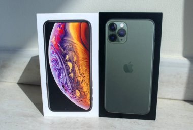 Dubai / Bae - 21 Eylül 2019: Işık arka planda iki kutu yeni apple iphone 11 pro ve iphone xs. 