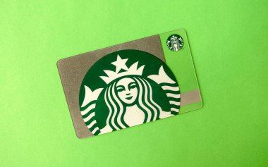 Dubai / BAE - 7 Haziran 2020: Yeşil ve gümüş rengi Starbucks hediye kartı yeşil arka planda izole edilmiş. Üst görünüm  