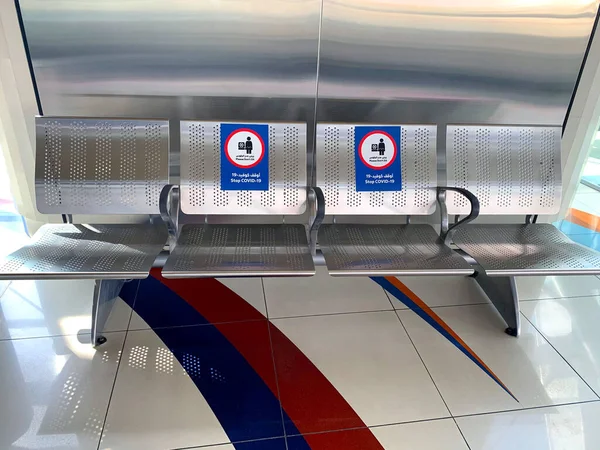 Dubai / BAE - 9 Haziran 2020: İngilizce ve Arapça dillerinde metro istasyonundaki koltuklara 