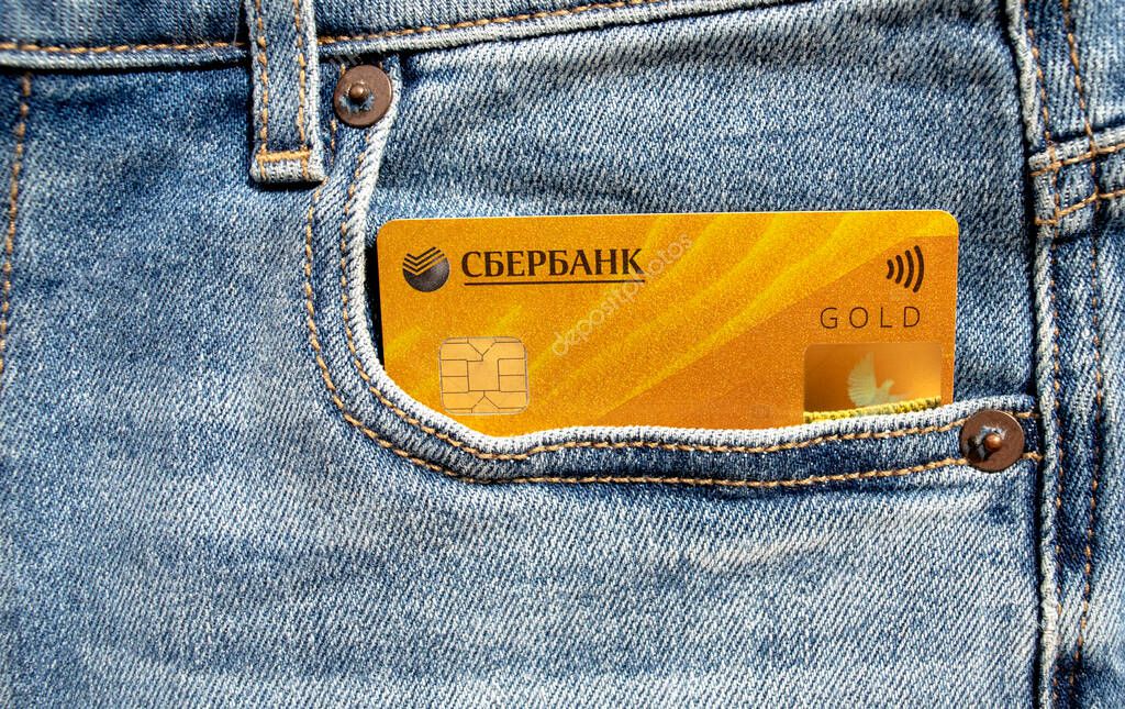 Dubai / UAE - June 7, 2020: Sberbank plastic Visa Gold debit card in a jeans front pocket. Sberbank of Russia.