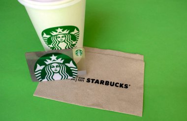 Dubai / BAE - 7 Haziran 2020: Starbucks beyaz kahve fincanı hediye kartı ve yeşil arka planda fotokopi alanı olan peçete 