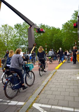 Amsterdam / Hollanda - 11 Temmuz 2019: Köprüden bisikletle geçen bir sürü insan, bisiklet, aktif yaşam tarzı, bisikletçiler, ulaşım, işlek yol