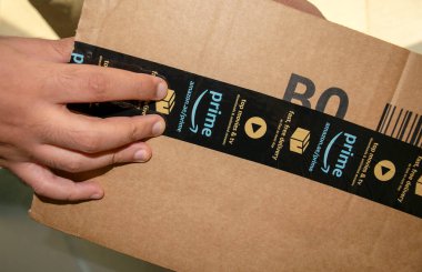 Dubai - BAE - Temmuz 04, 2020: İnsanoğlu Amazon 'un karton kutu paketini açıyor. Amazon asal ücretsiz dağıtım paketi.