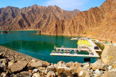 Hatta / BAE - 18 Temmuz 2020: Hajar Dağları arasında çok sayıda kano ve tekne kiralanan güzel, koyu yeşil Hatta Gölü. Hatta barajının BAE 'deki genel görünümü. 