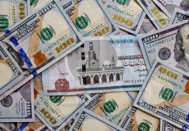 Mısır ulusal banknotu ABD ulusal para biriminin üstünde, karışık Amerikan doları banknotlarının en üst görüntüsü. Mısır ve ABD kağıt parası. 5 pound ve döviz kuru. USD, EGP