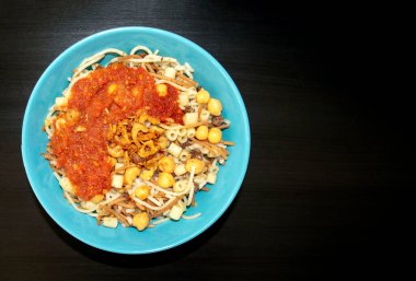 Ünlü geleneksel Arapça, Mısır yemeği Koshari. Ulusal Kushari turkuaz bir plaka içinde koyu tahta arka planda fotokopi alanı ile. Düz yatış, üst görünüm.