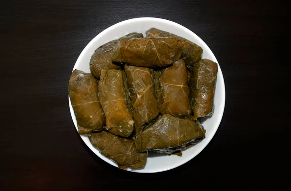 Feuilles de raisin farcies sur plaque blanche sur fond bois foncé. Célèbre Moyen-Orient traditionnel, cuisine turque et asiatique. Dolma ! — Photo